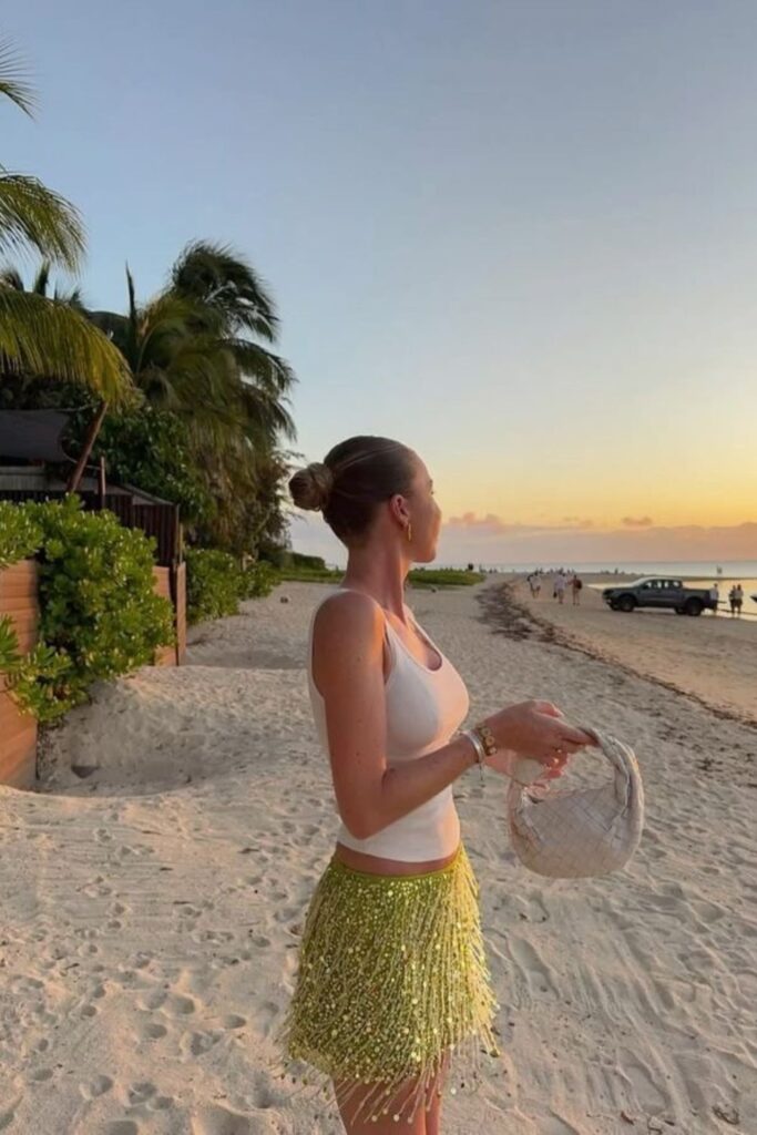 19 Chicest Beach Outfits That Belong in Your Summer Photo Dump minimalist cream tank & sequin fringe mini skirt