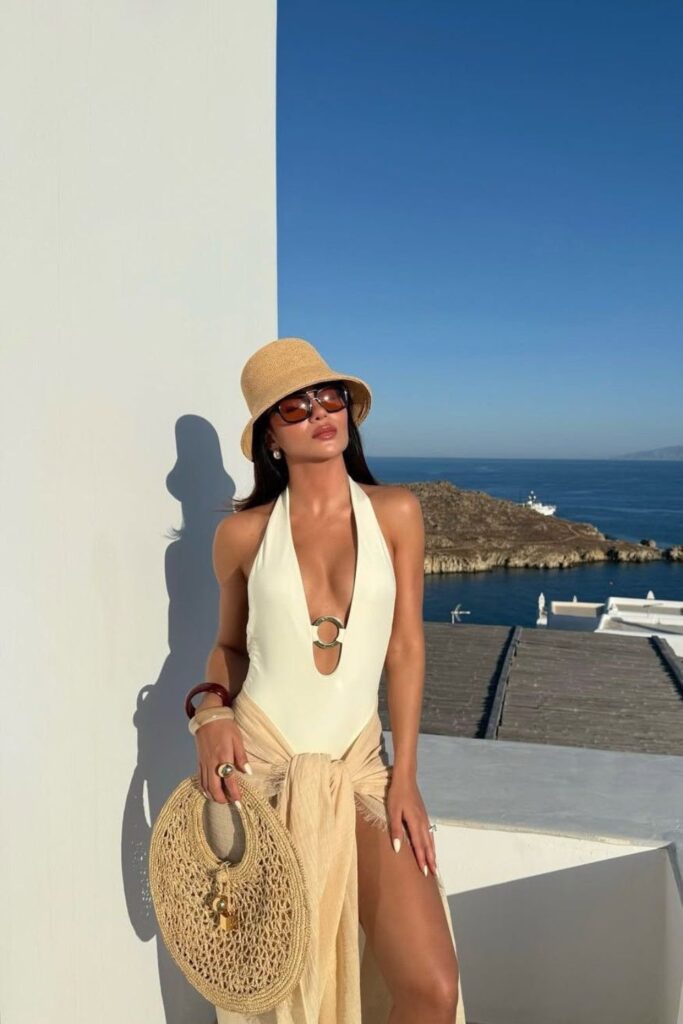 19 Chicest Beach Outfits That Belong in Your Summer Photo Dump plunging halter swimsuit & straw bucket hat