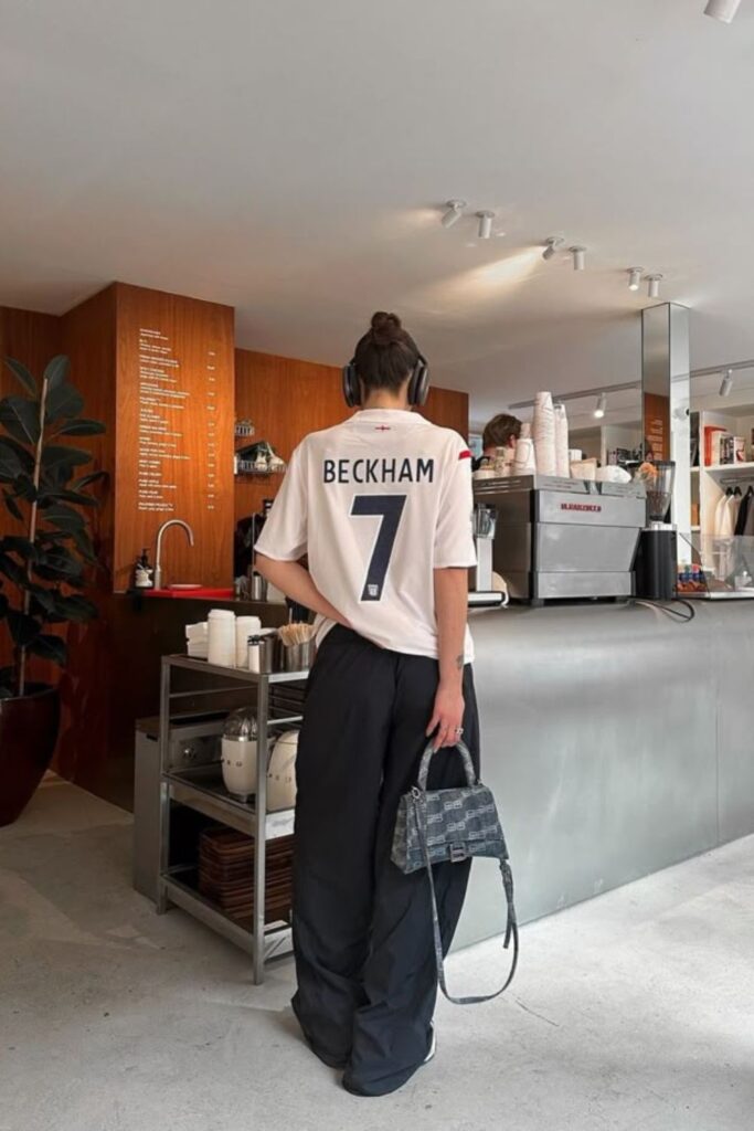 18 Football Jersey Outfits You’ll Want to Wear Even When You’re Not at a Game vintage team jersey with parachute pants